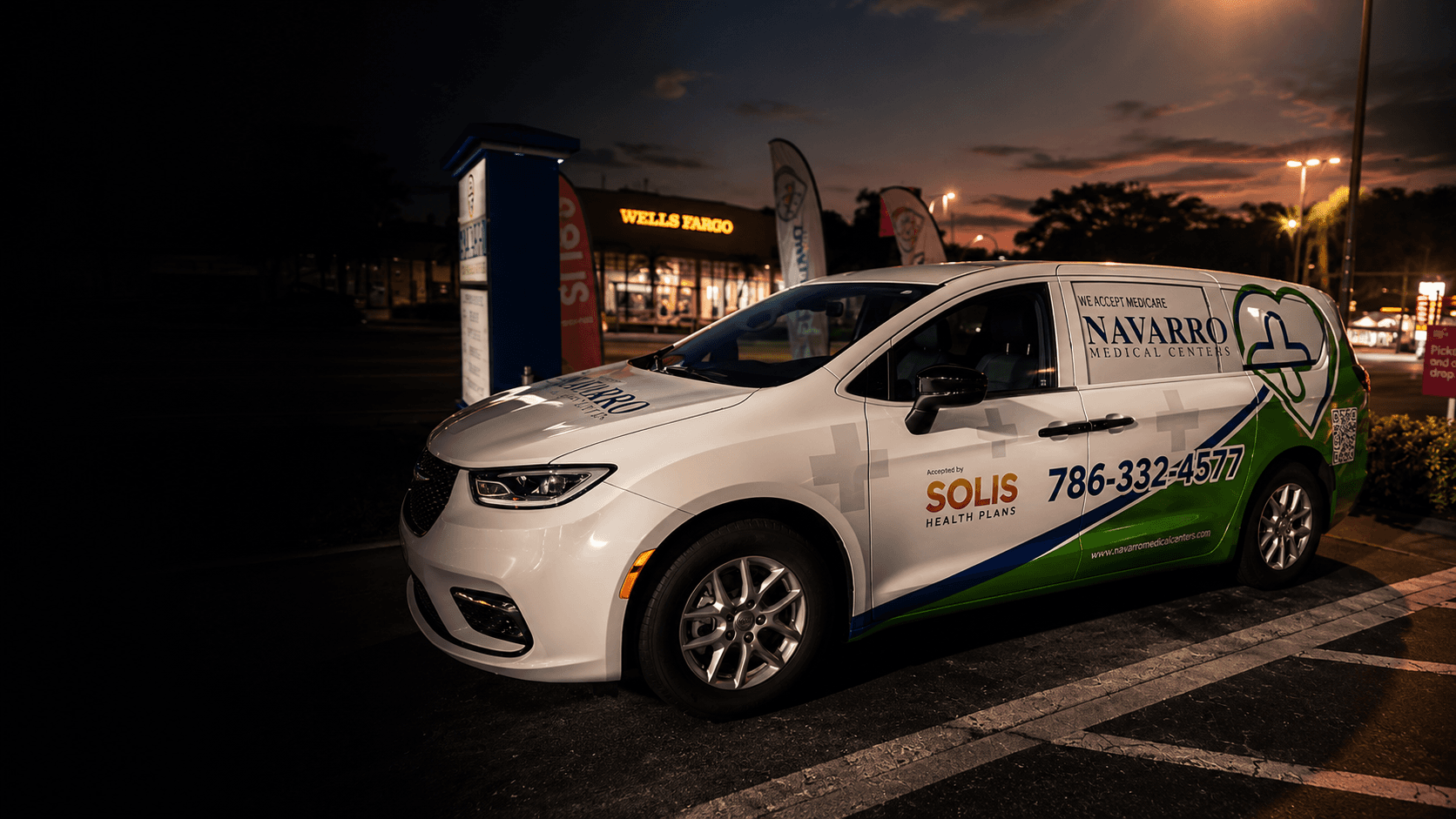 Navarro Medical Centers passenger van with a full brand wrap parked in a plaza at dusk