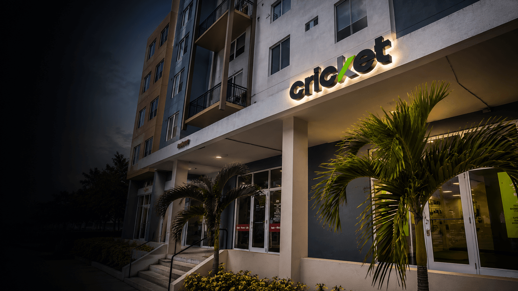 Illuminated Cricket Wireless channel letters integrated into a Miami commercial building at dusk.