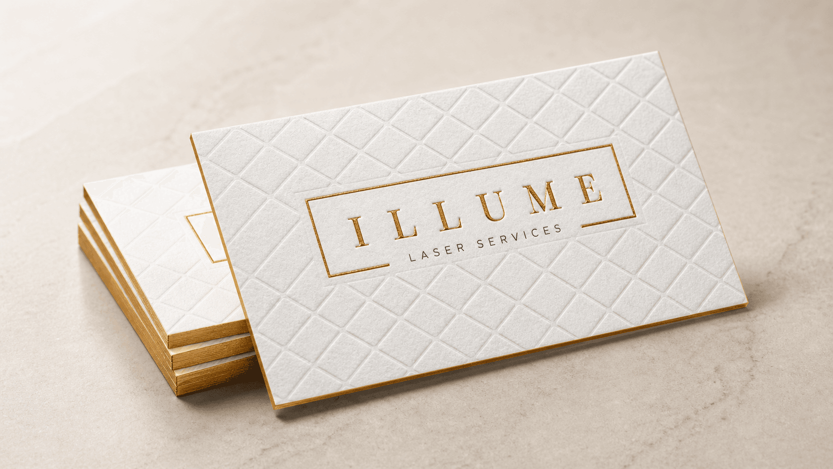 White cotton business cards with blind embossing, gold foil and gilded edges
